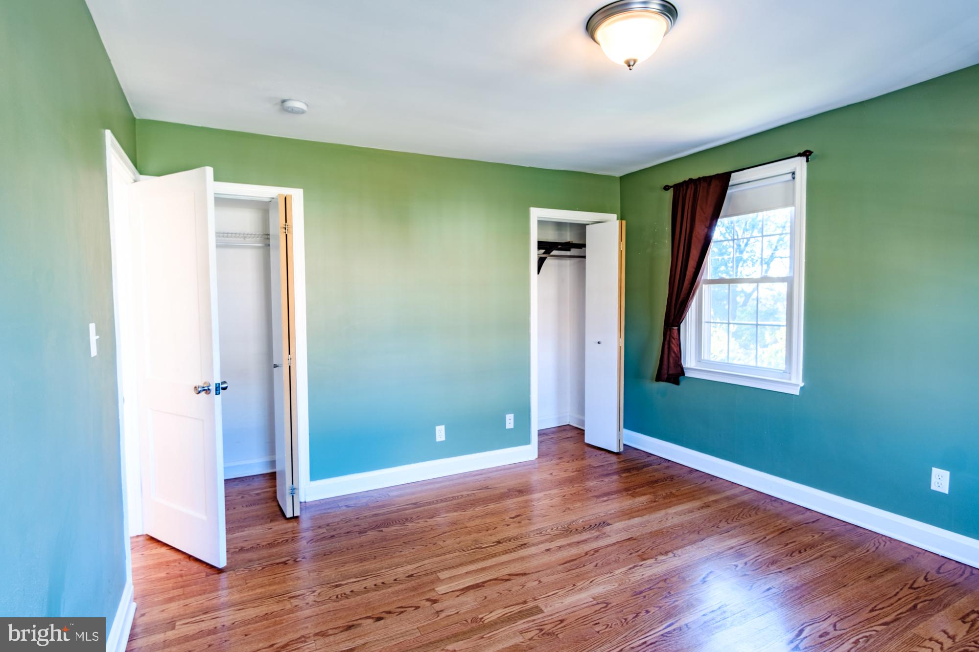 8501 Pleasant Plains Road Baltimore, MD 21286 - Photo 47 of 53 an empty room with wooden floor and windows