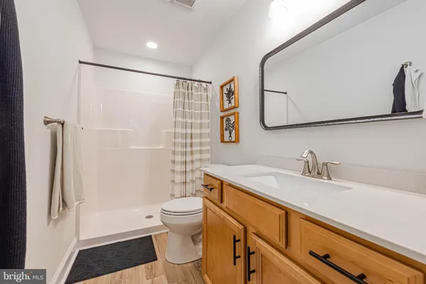 a bathroom with a granite countertop sink toilet and shower