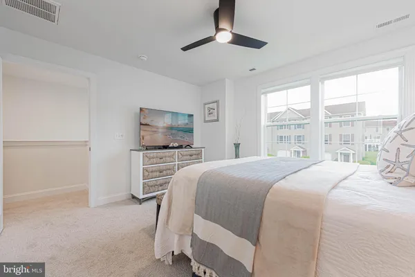 a bedroom with a large bed and a flat tv screen on dresser