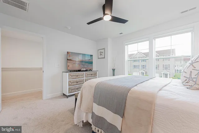 a bedroom with a large bed and a flat tv screen on dresser