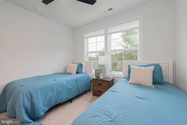 a bedroom with two beds and a large window