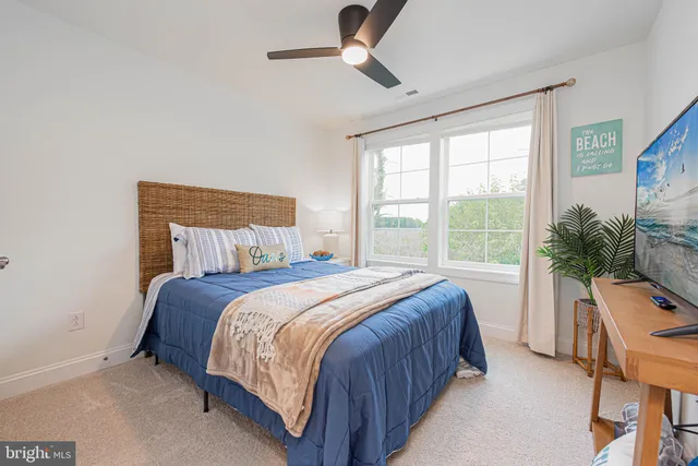 a bedroom with a bed a chandelier and a large window