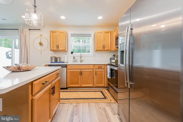 a kitchen with stainless steel appliances a sink stove and refrigerator