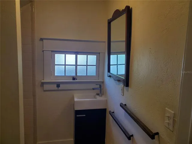 a living room with furniture a bookshelf and a window