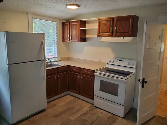 a kitchen with stainless steel appliances granite countertop a refrigerator and a stove
