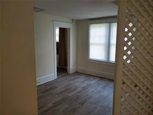 a bed sitting in a bedroom next to a window