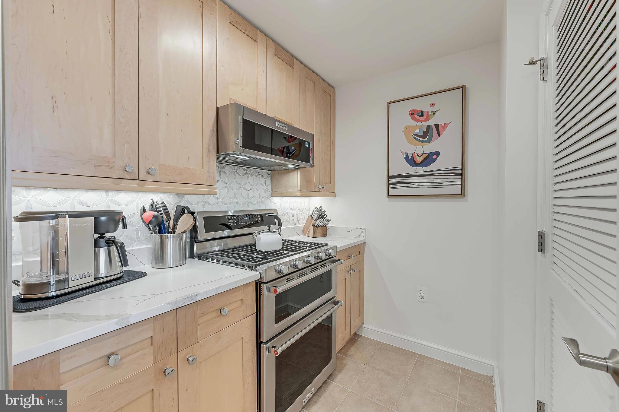 11990 Market Street, Unit 414 Reston, VA 20190 - Photo 17 of 52 a kitchen with stainless steel appliances granite countertop a stove and a microwave