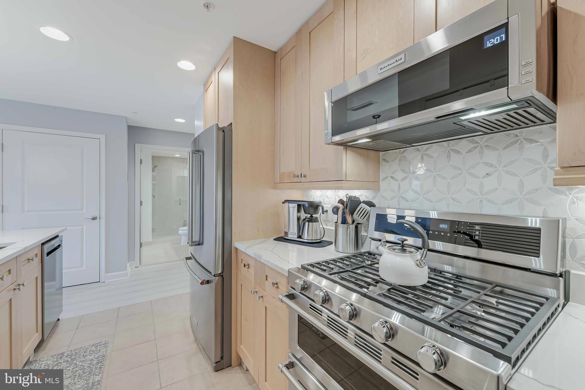 11990 Market Street, Unit 414 Reston, VA 20190 - Photo 19 of 52 a kitchen with a stove and a microwave