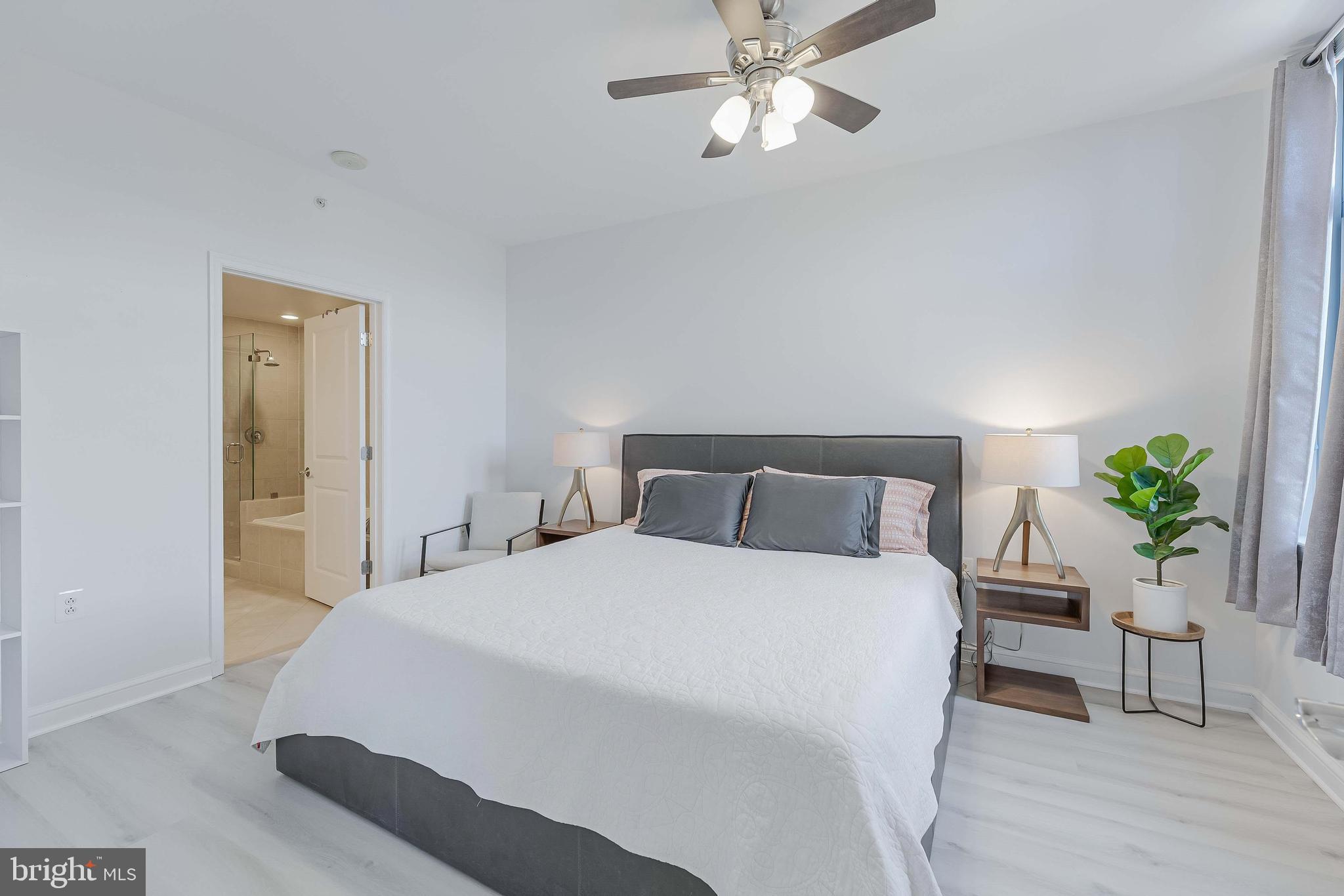 11990 Market Street, Unit 414 Reston, VA 20190 - Photo 27 of 52 a bedroom with a bed and a potted plant