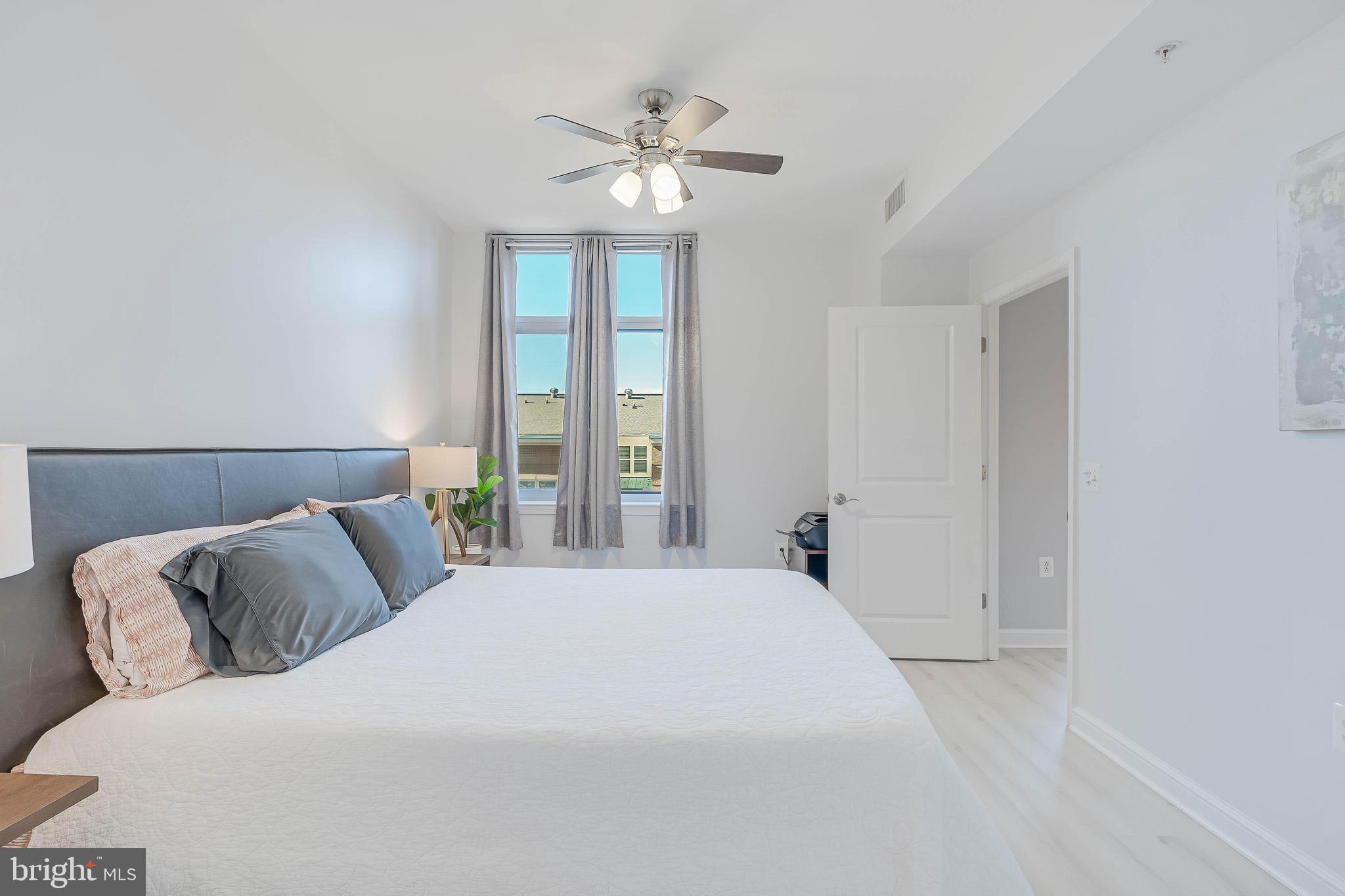 11990 Market Street, Unit 414 Reston, VA 20190 - Photo 29 of 52 a bedroom with a large bed and a large window