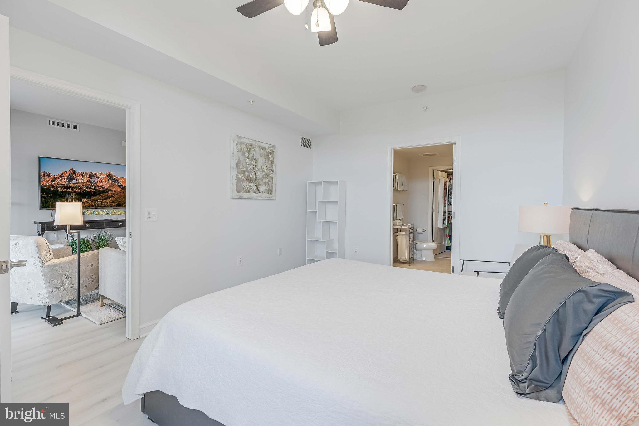 11990 Market Street, Unit 414 Reston, VA 20190 - Photo 30 of 52 a bedroom with a bed and a chandelier