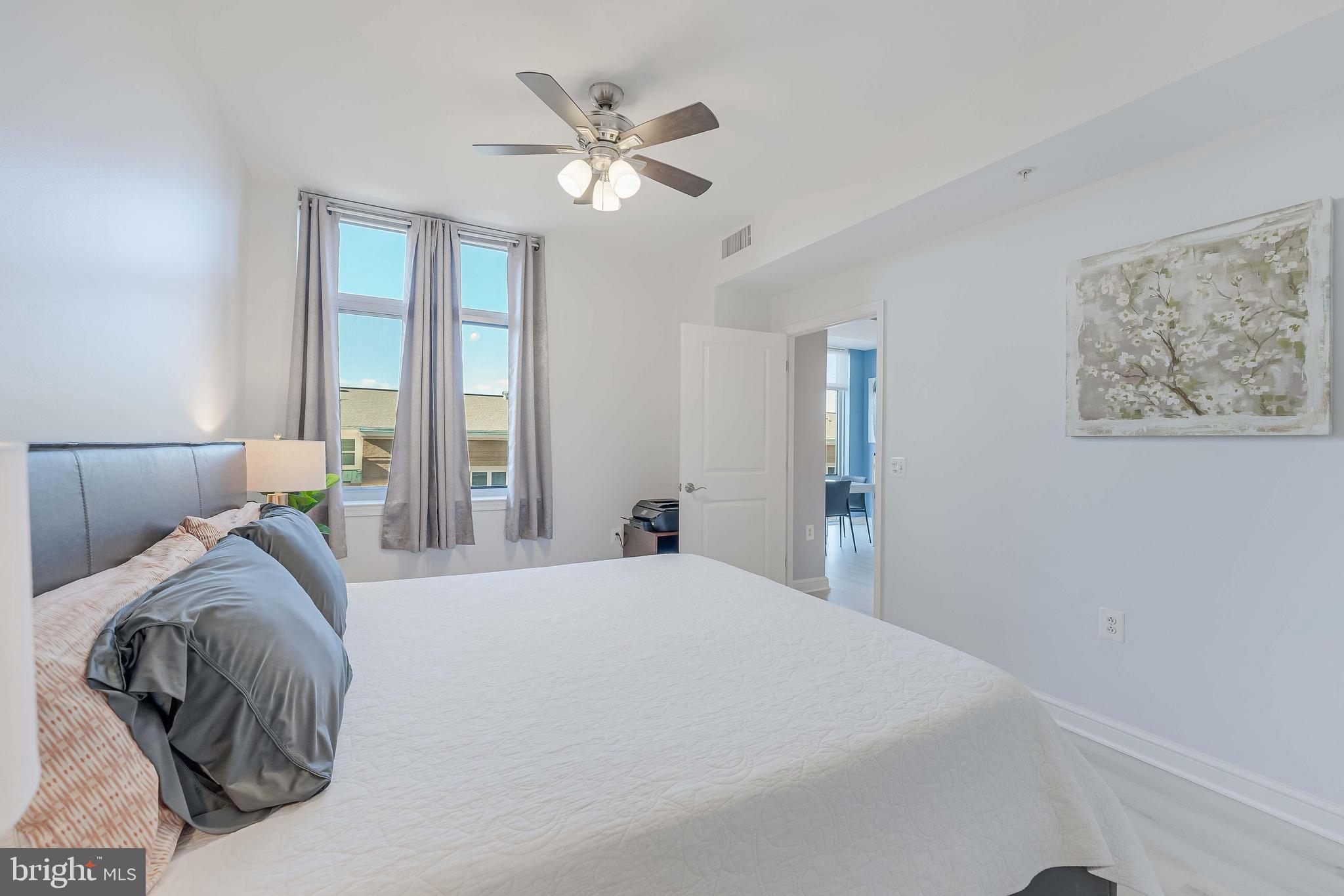 11990 Market Street, Unit 414 Reston, VA 20190 - Photo 31 of 52 a bedroom with a large bed and a chandelier