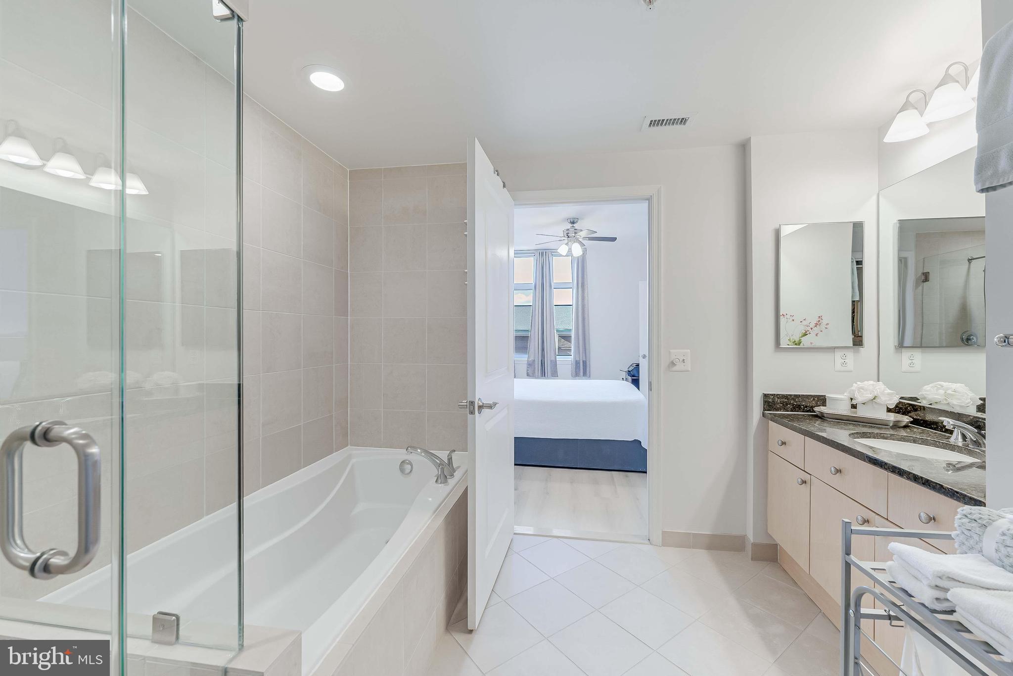 11990 Market Street, Unit 414 Reston, VA 20190 - Photo 35 of 52 a bathroom with a tub a sink and a shower