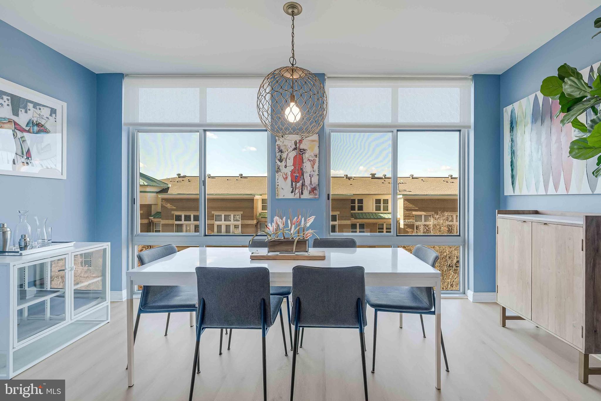 11990 Market Street, Unit 414 Reston, VA 20190 - Photo 6 of 52 a dining room with furniture a chandelier and wooden floor