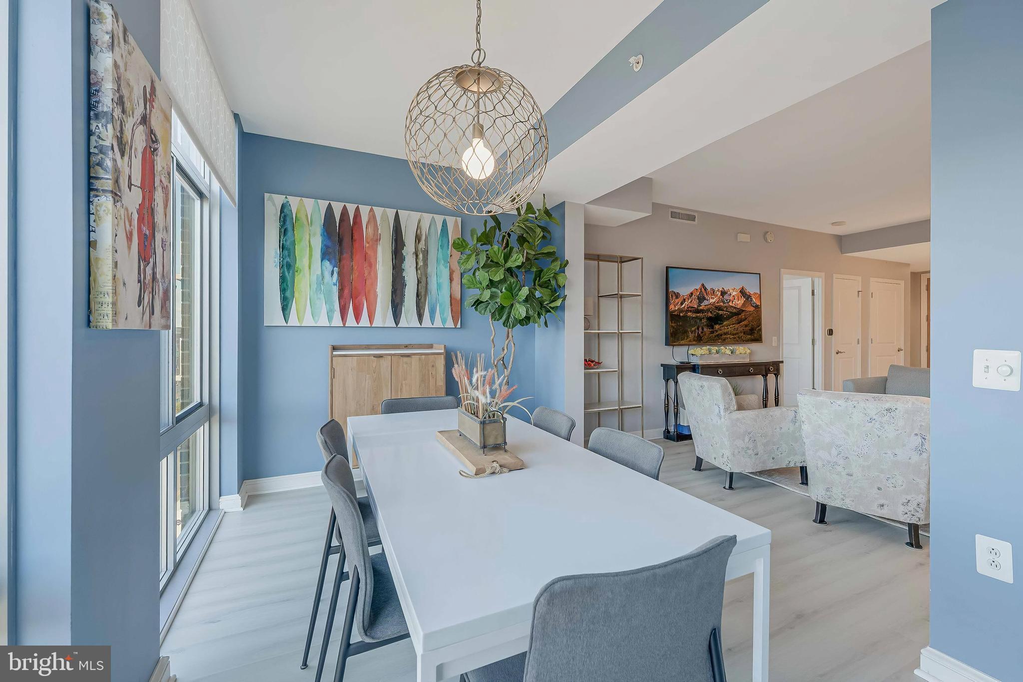 11990 Market Street, Unit 414 Reston, VA 20190 - Photo 7 of 52 a view of a dining room with furniture a chandelier and wooden floor