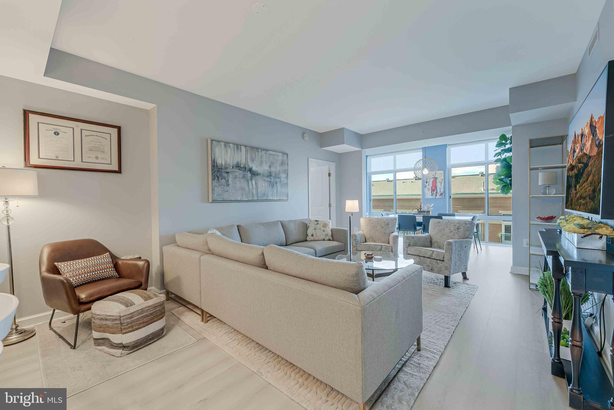 11990 Market Street, Unit 414 Reston, VA 20190 - Photo 10 of 52 a living room with furniture and a flat screen tv