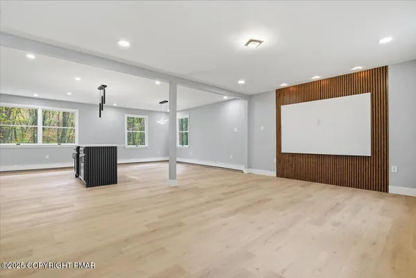 a view of an empty room with kitchen appliances and windows