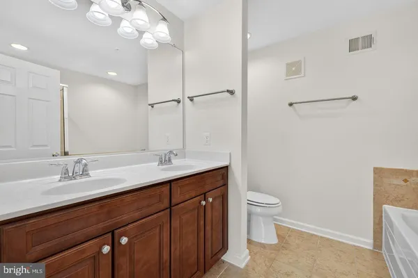 a bathroom with a double vanity sink mirror and toilet