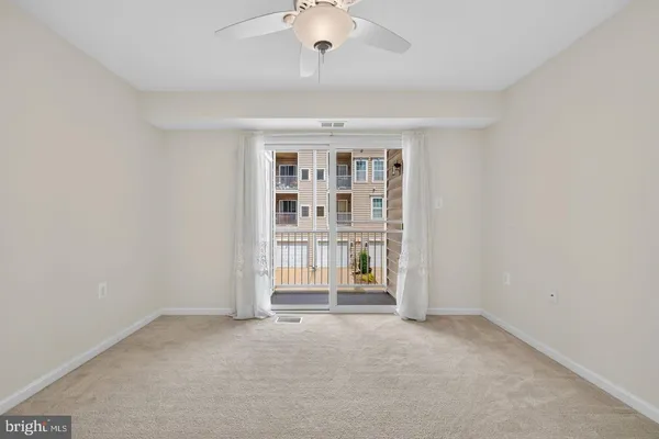 an empty room with cabinet and windows