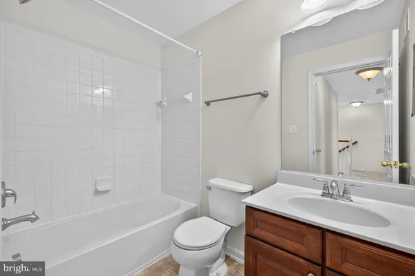 a bathroom with a granite countertop sink toilet a mirror and shower