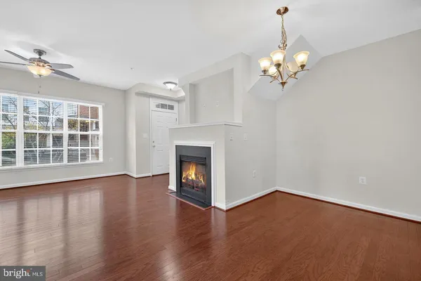 a view of an empty room with a fireplace and wooden floor