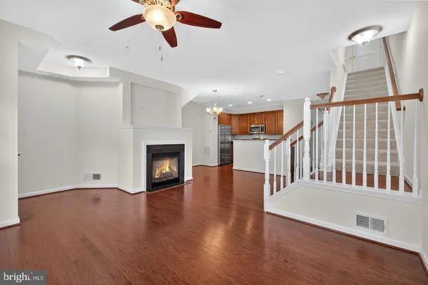a view of a livingroom with wooden floor and a ceiling fan