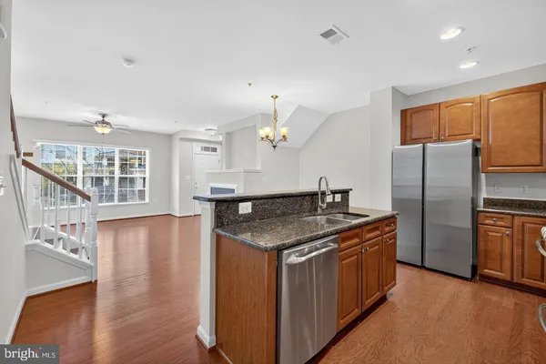 a kitchen with stainless steel appliances granite countertop a sink a stove and a refrigerator