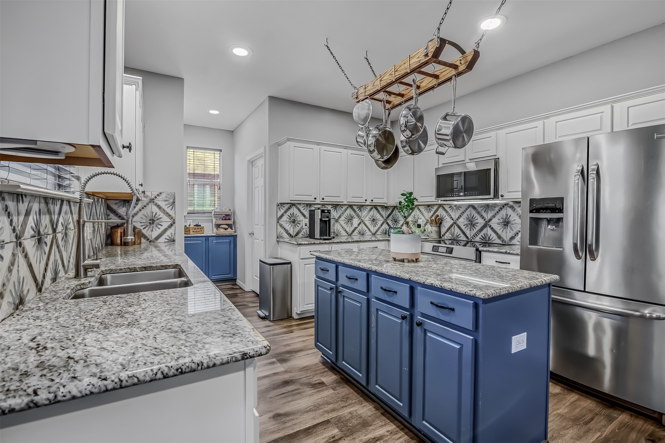 19303 Young Oak Street Spring, TX 77379 - Photo 9 of 29 The updated kitchen is ready for it's new chef. It features luxury vinyl flooring, plenty of prep space with granite countertops and decorative tile backsplash.