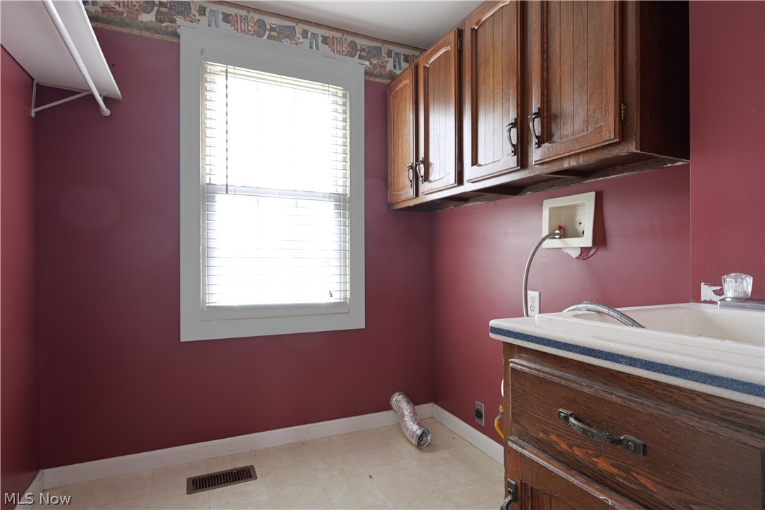 19105 Whitehead Road Lagrange, OH 44050 - Photo 16 of 37 Laundry area featuring washer hookup, cabinets, and light tile patterned floors