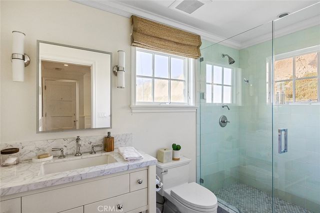 a bathroom with a granite countertop sink toilet a mirror and shower