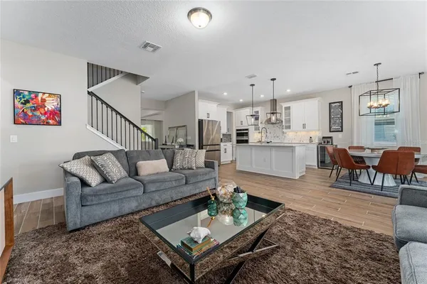 a living room with furniture and a dining table with kitchen view