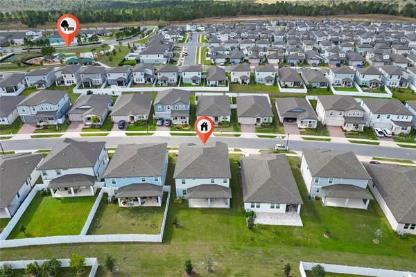 an aerial view of residential houses with outdoor space and parking