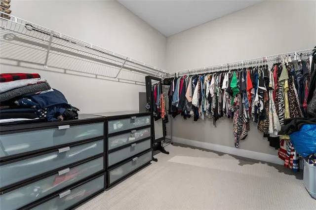 a view of walk in closet with clothes and shoes