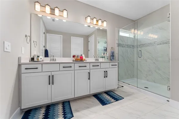 a spacious bathroom with double sink and mirror