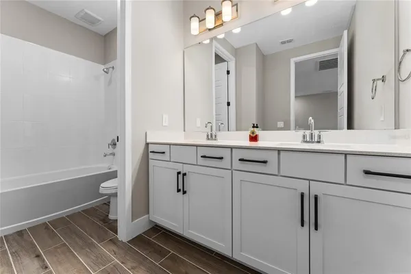 a bathroom with a double vanity sink a mirror and a bathtub