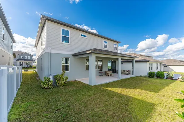 a view of a house with patio and a yard