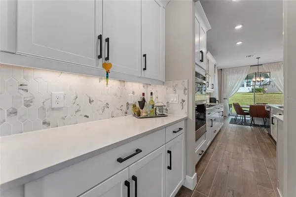 a kitchen with stainless steel appliances white cabinets and wooden floor