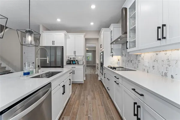 a large kitchen with stainless steel appliances lots of counter space and wooden floor