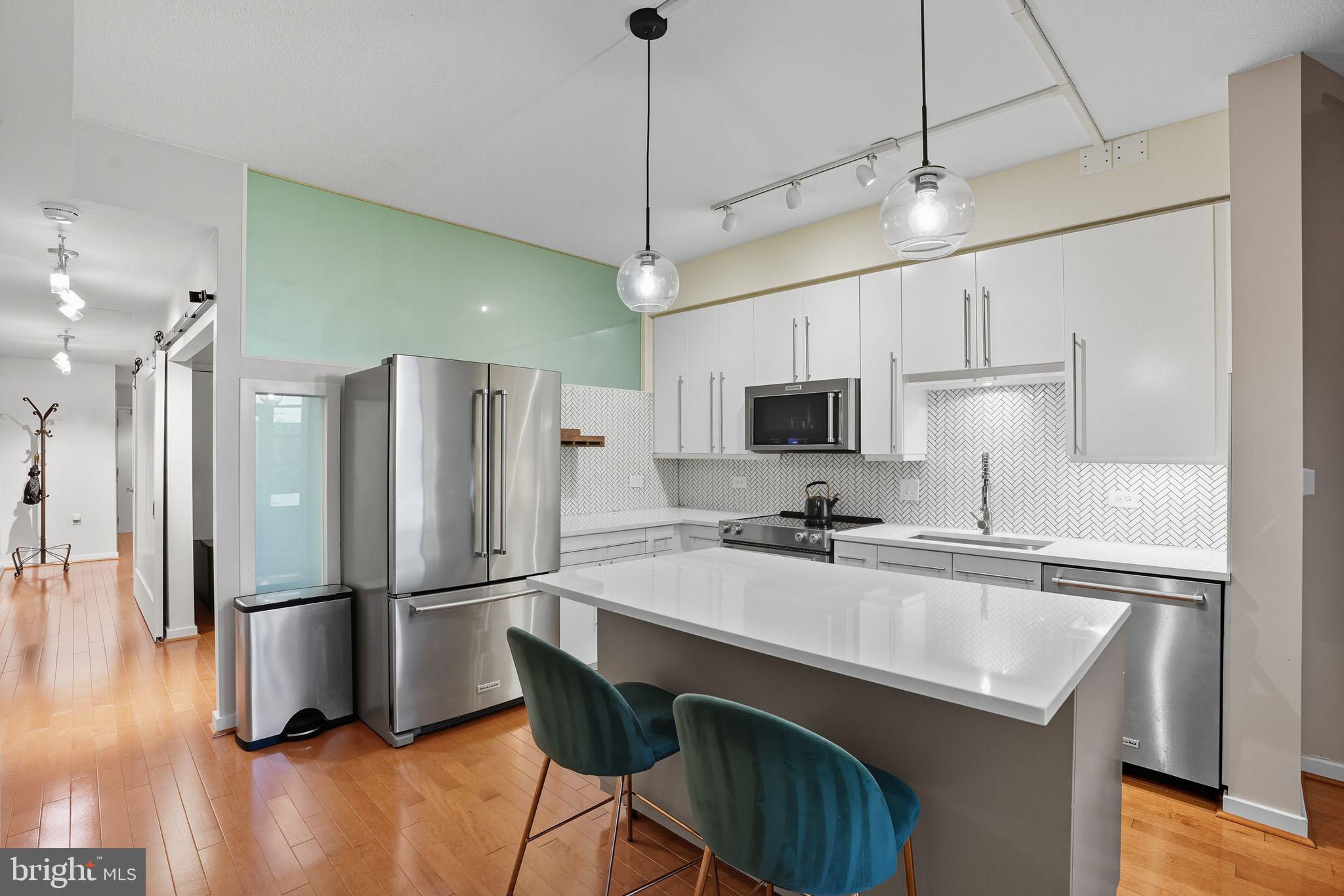 437 New York Avenue Northwest, Unit 222 Washington, DC 20001 - Photo 2 of 20 a kitchen with kitchen island a counter top space stainless steel appliances and wooden floor