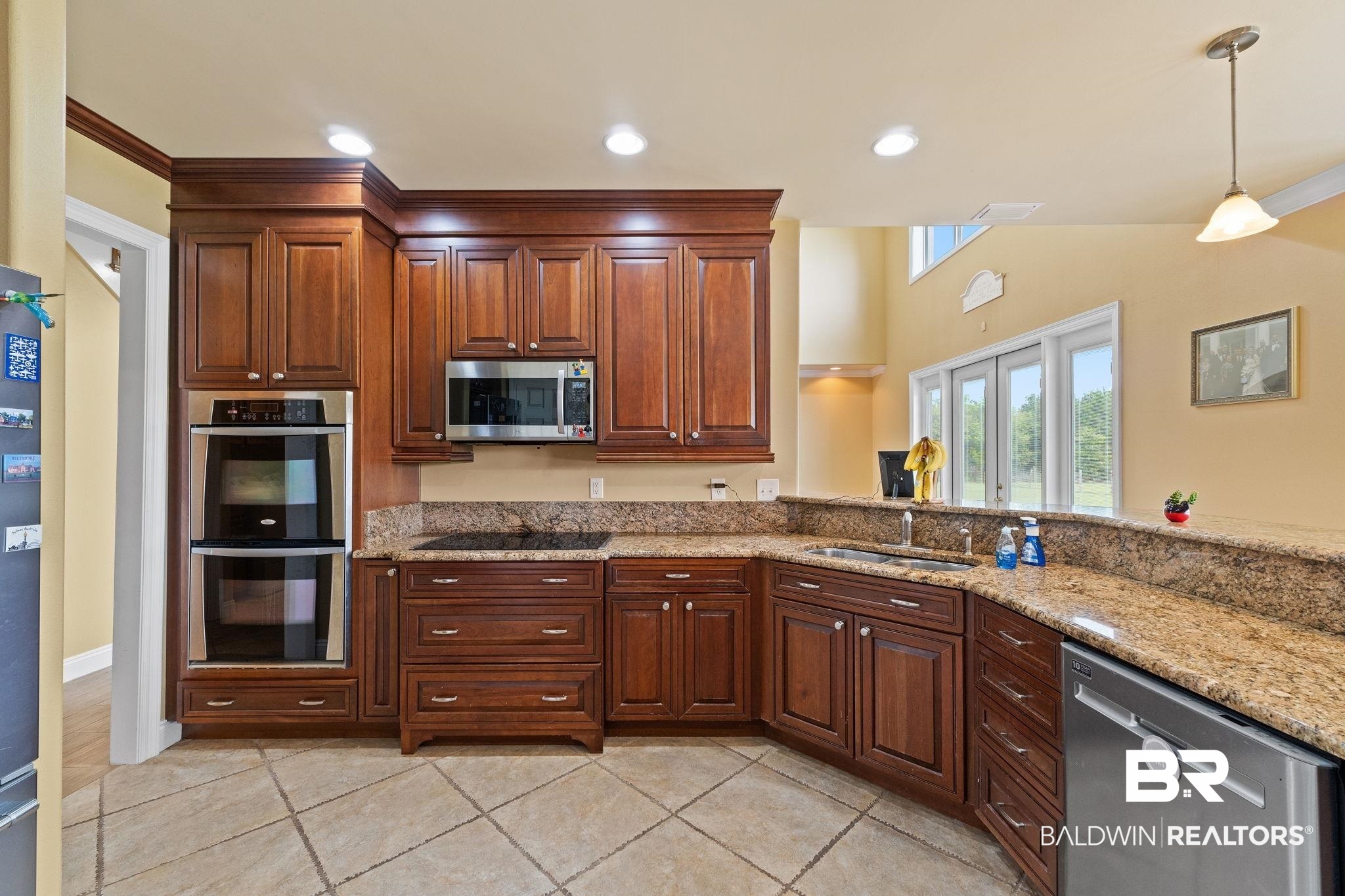9790 Stucki Road Elberta, AL 36530 - Photo 36 of 72 Kitchen featuring stainless steel appliances, a sink, light tile patterned floors, hanging light fixtures, and ornamental molding