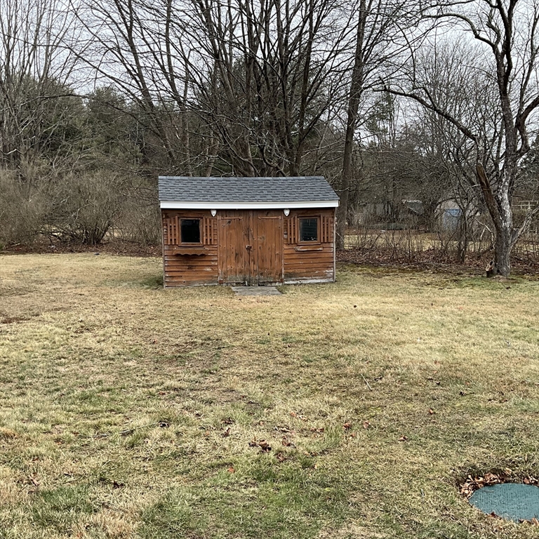 93 Plain Street Mansfield, MA 02048 - Photo 5 of 20 a backyard of a house with large trees and brick wall