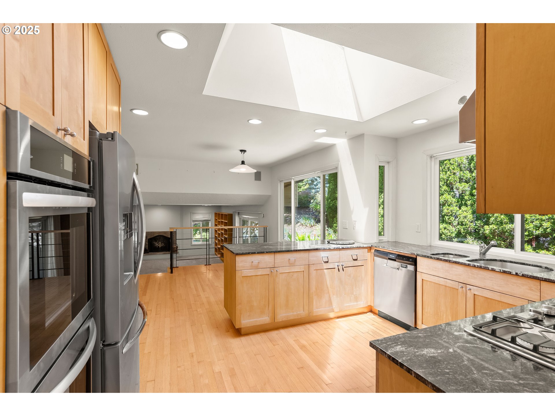 680 Northwest Torryview Lane Portland, OR 97229 - Photo 5 of 18 a kitchen with stainless steel appliances granite countertop a refrigerator a sink dishwasher a stove and a dining table with wooden floor