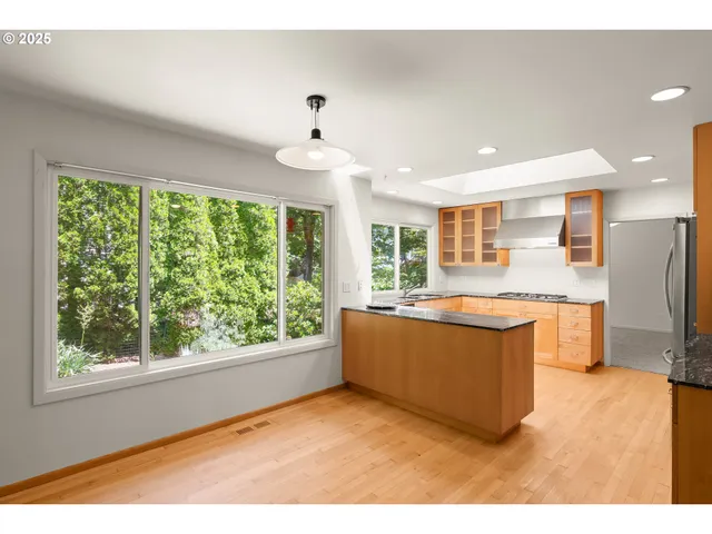 a living room with stainless steel appliances kitchen island furniture and a large window