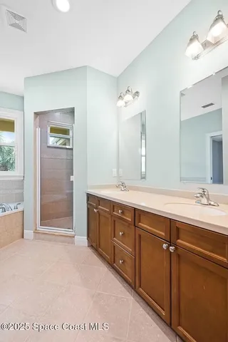 a spacious bathroom with a tub sink and mirror