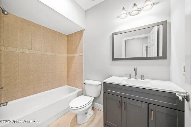 a bathroom with a toilet a sink a mirror and bathtub