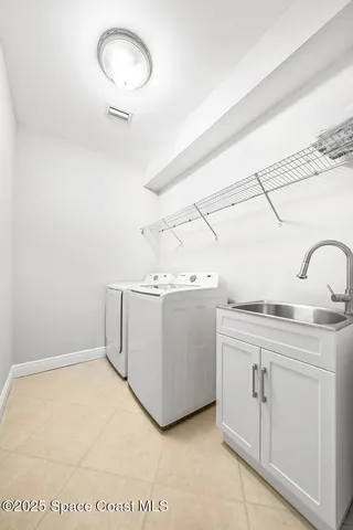 a room with a sink washer and dryer