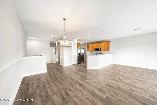 a view of a kitchen with a sink and wooden floor