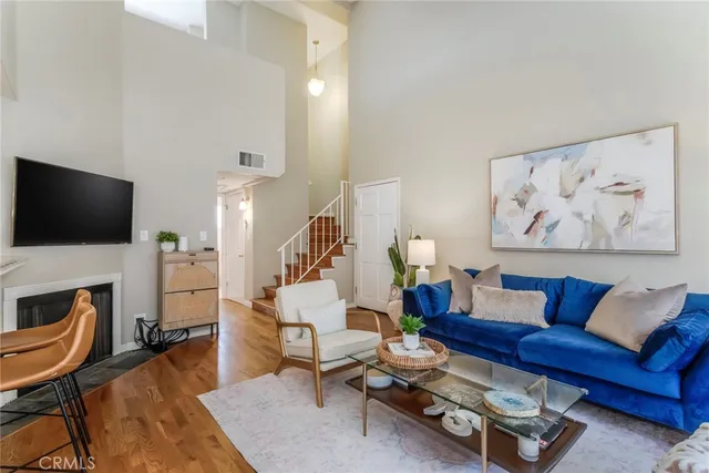 a living room with furniture a flat screen tv and a fireplace