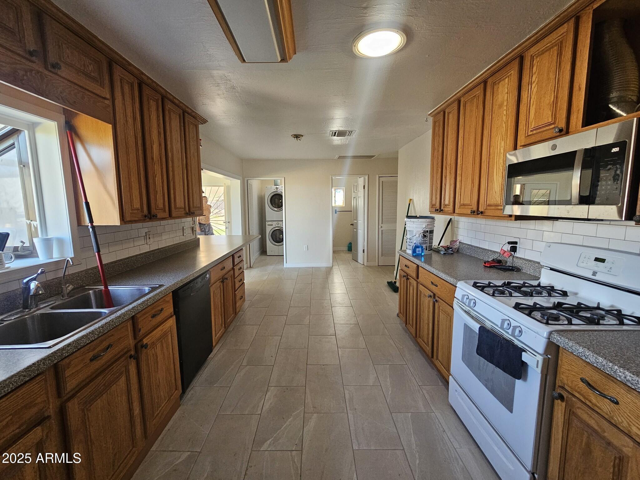 819 East Apollo Road Phoenix, AZ 85042 - Photo 4 of 17 a kitchen with stainless steel appliances a stove a sink cabinets and a kitchen island