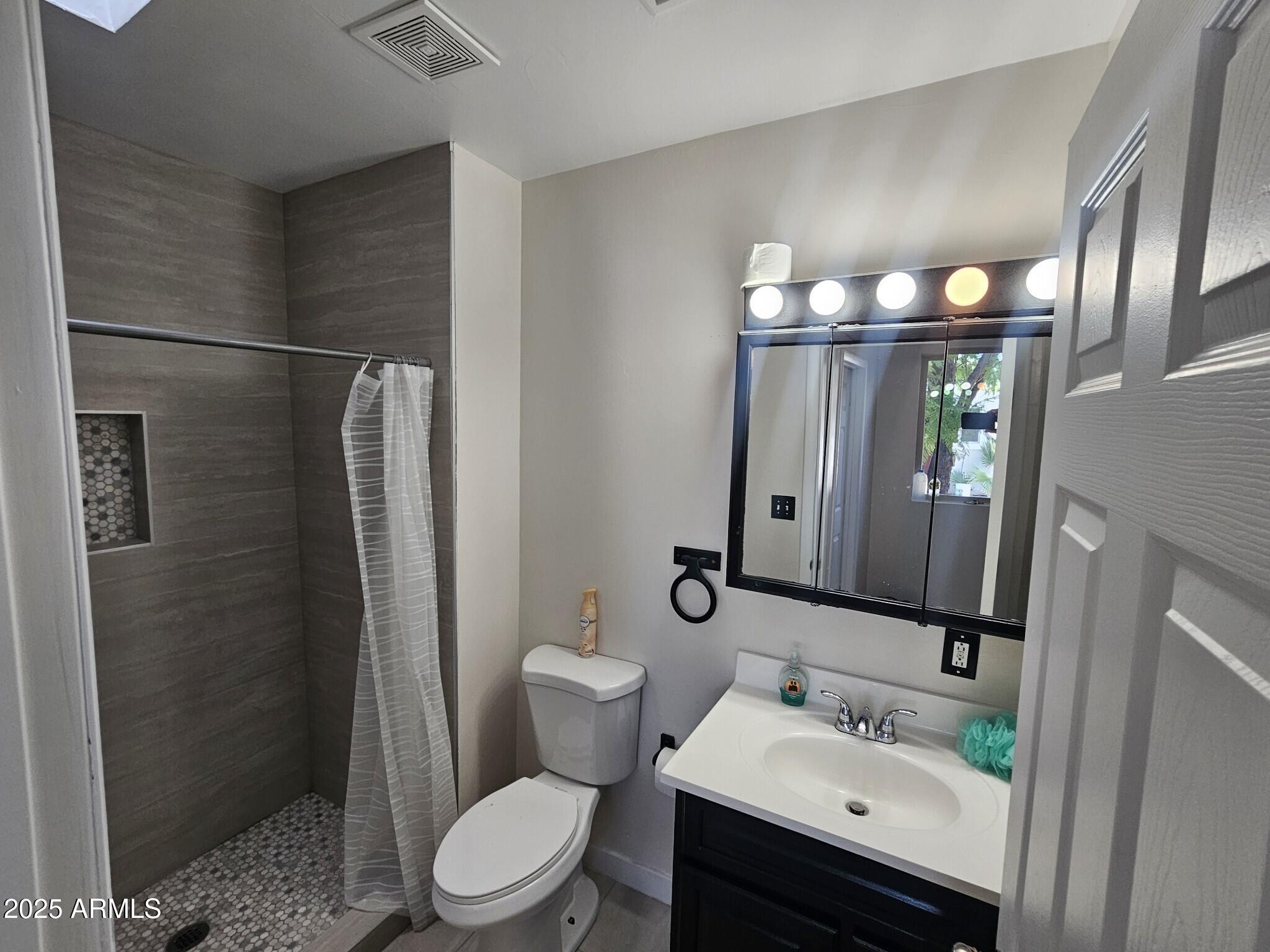 819 East Apollo Road Phoenix, AZ 85042 - Photo 9 of 17 a bathroom with a sink toilet and shower